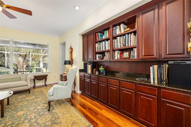 living area with crown molding, ceiling fan, and light hardwood / wood-style floors