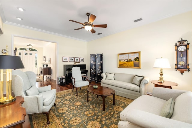 living room featuring ceiling fan, ornamental molding, and wood-type flooring