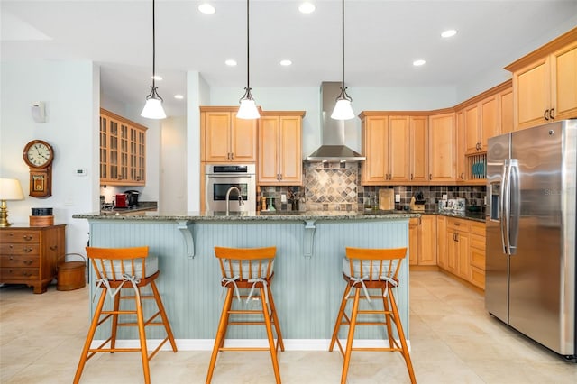 kitchen with pendant lighting, a center island with sink, a kitchen breakfast bar, and appliances with stainless steel finishes