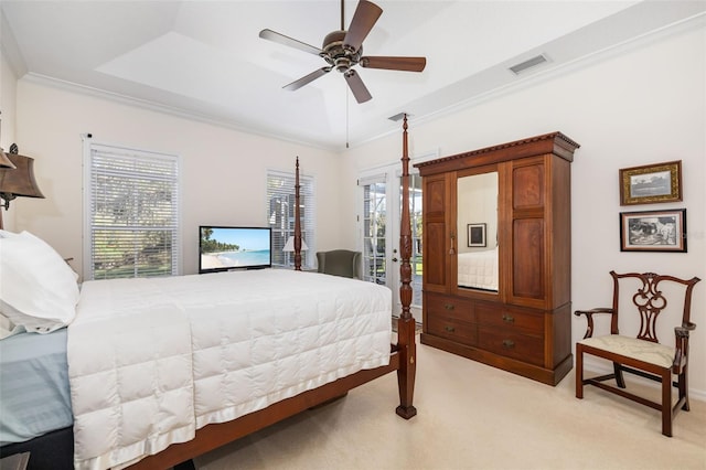 carpeted bedroom featuring a tray ceiling, access to exterior, crown molding, and ceiling fan