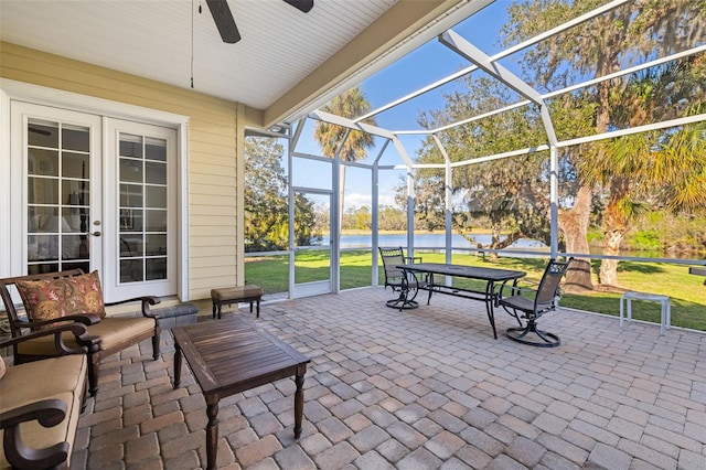 view of patio / terrace with a water view, a lanai, and french doors