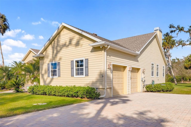 view of side of property with a garage and a yard