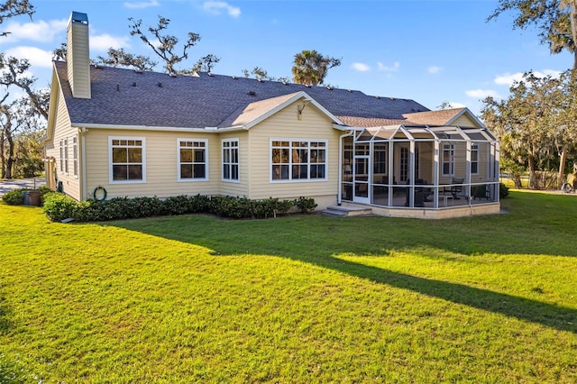 rear view of house with a lanai and a lawn