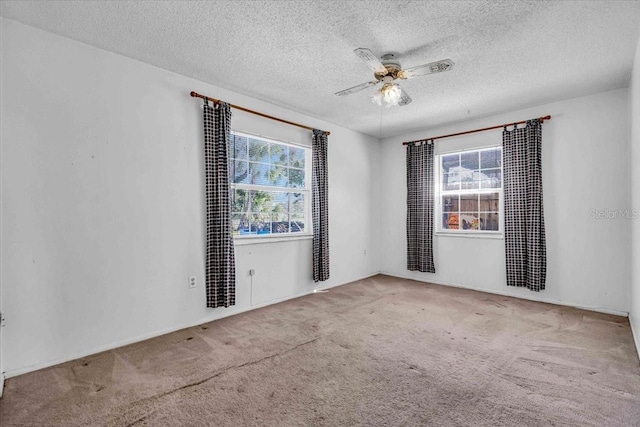 empty room featuring ceiling fan, carpet floors, and a textured ceiling