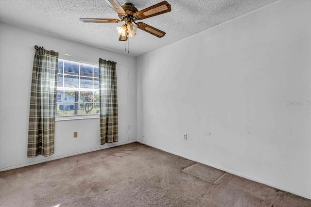 carpeted spare room featuring ceiling fan and a textured ceiling