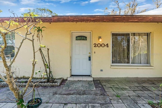 entrance to property with stucco siding