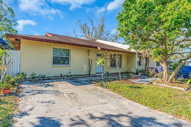 single story home with fence and stucco siding