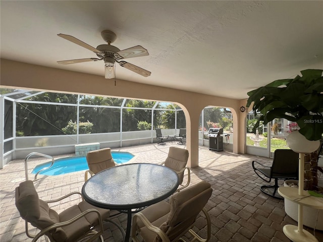 view of patio / terrace featuring grilling area, ceiling fan, and glass enclosure