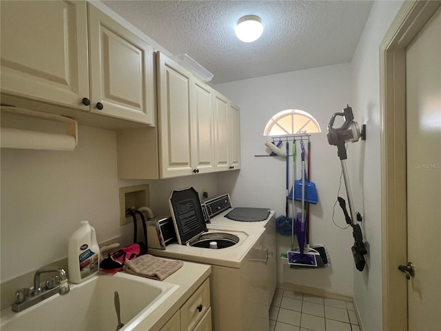 laundry area featuring sink, cabinets, light tile patterned floors, independent washer and dryer, and a textured ceiling