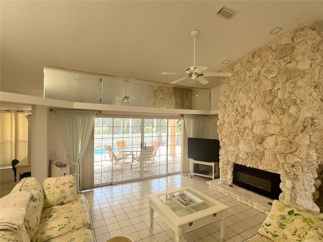 unfurnished living room with light tile patterned flooring, ceiling fan, and a stone fireplace