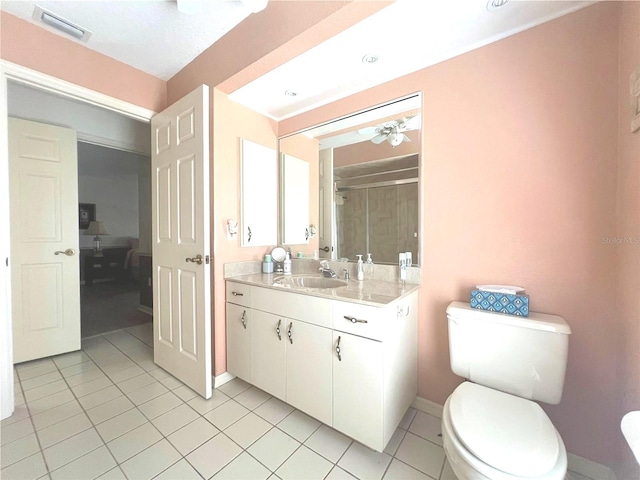 bathroom with vanity, ceiling fan, walk in shower, toilet, and tile patterned floors