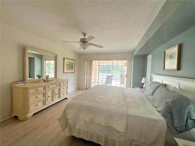 bedroom featuring ceiling fan, light carpet, and a textured ceiling