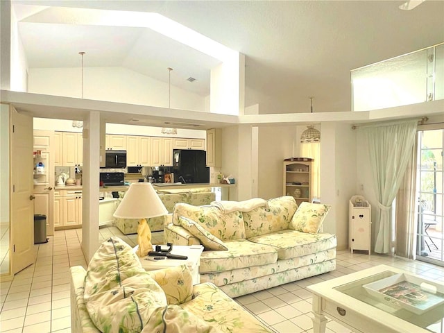living area with high vaulted ceiling and light tile patterned floors