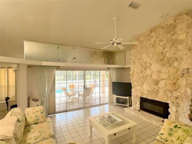 living area featuring light tile patterned floors, visible vents, a high ceiling, and ceiling fan