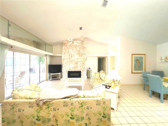 living room featuring ceiling fan, lofted ceiling, a stone fireplace, and visible vents