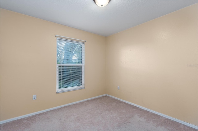 empty room with baseboards and light colored carpet