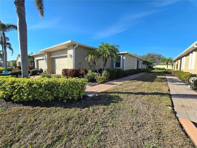 view of home's exterior featuring a yard, an attached garage, and stucco siding