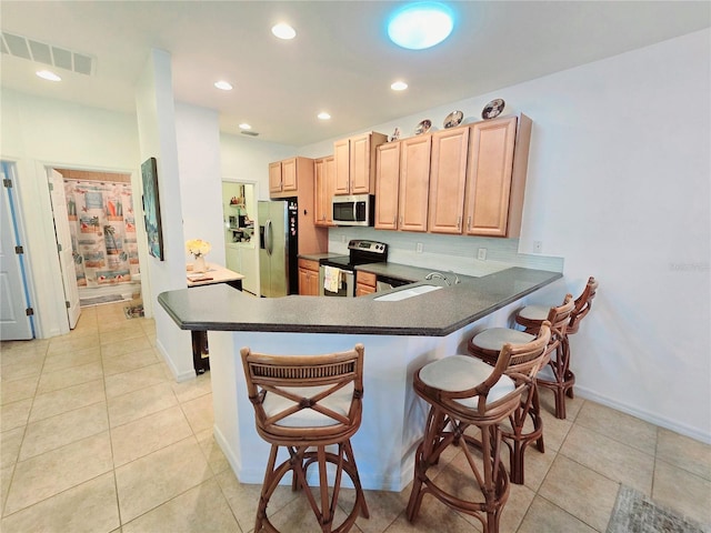 kitchen with stainless steel appliances, a peninsula, a sink, visible vents, and dark countertops