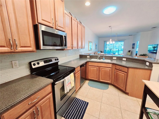 kitchen featuring light tile patterned floors, a peninsula, hanging light fixtures, stainless steel appliances, and a sink