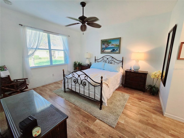 bedroom with a ceiling fan, light wood-type flooring, and baseboards