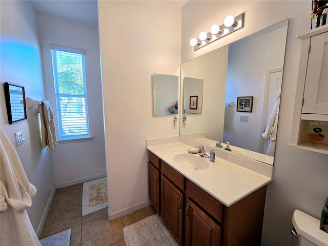 bathroom with baseboards, vanity, toilet, and tile patterned floors