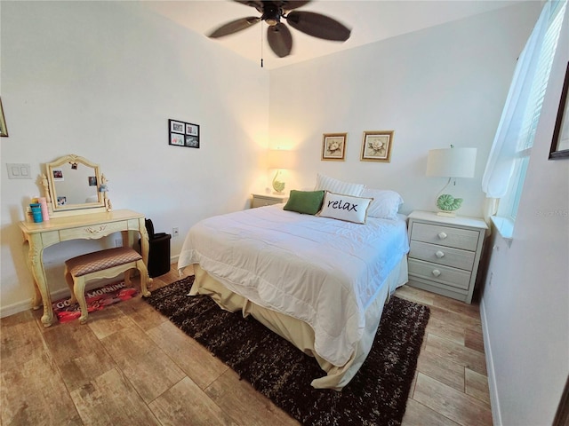 bedroom featuring light wood-type flooring, a ceiling fan, and baseboards