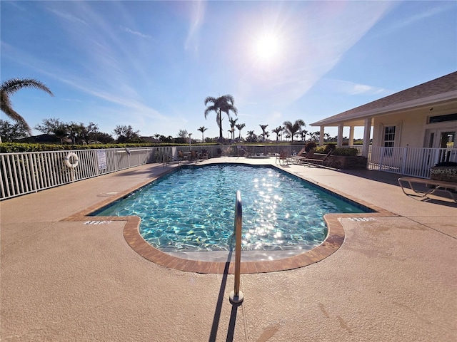 community pool featuring fence and a patio