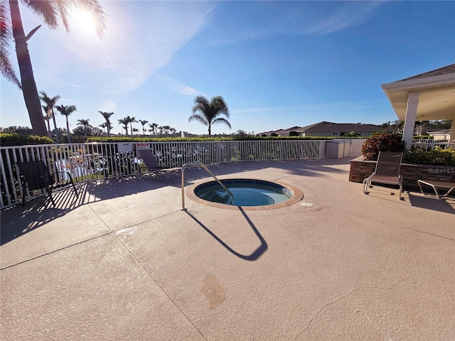 view of swimming pool featuring a community hot tub, a patio, and fence