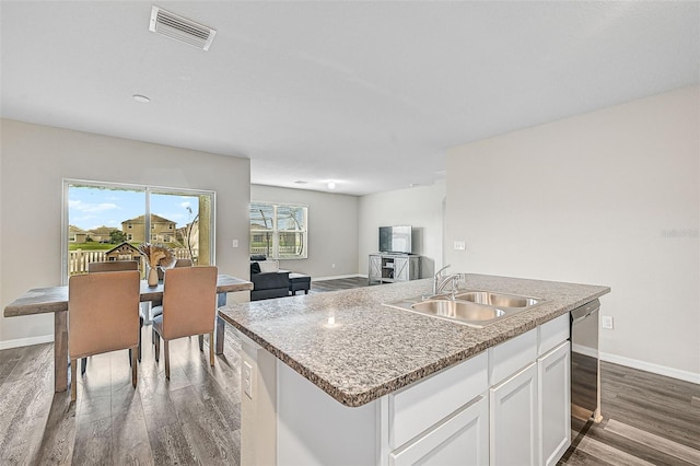 kitchen with sink, white cabinetry, dishwasher, dark hardwood / wood-style flooring, and a kitchen island with sink