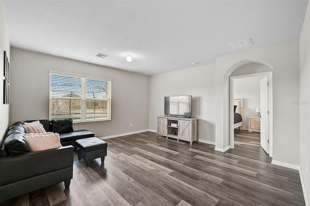 living room featuring dark hardwood / wood-style flooring and a textured ceiling