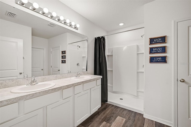 bathroom featuring vanity, a shower with curtain, wood-type flooring, and a textured ceiling