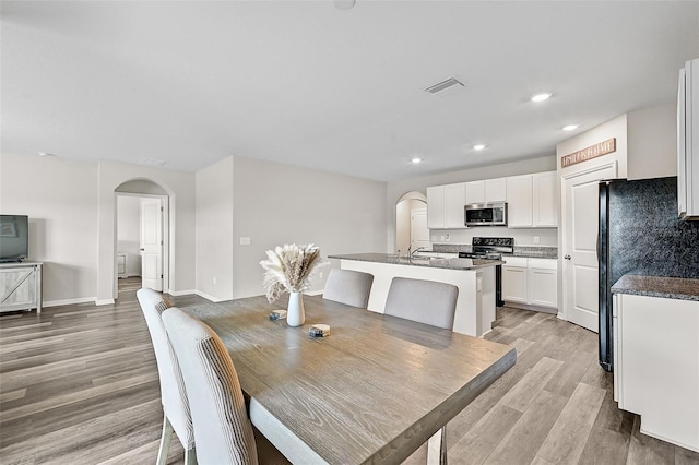 dining space with light wood-type flooring and sink