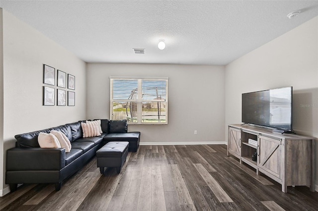 living room with dark hardwood / wood-style floors and a textured ceiling