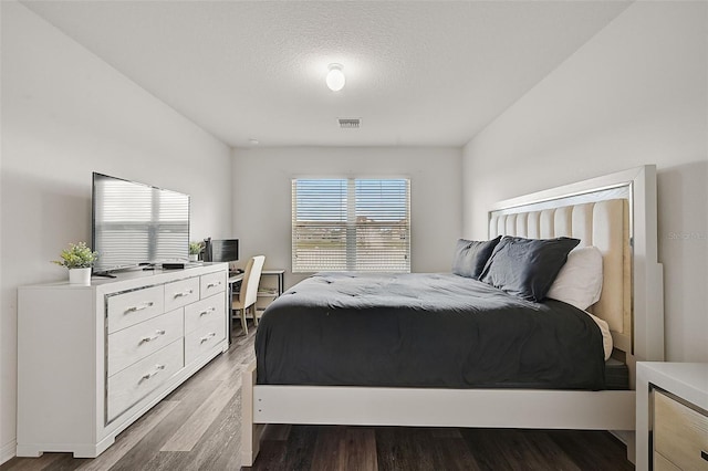 bedroom featuring a textured ceiling and hardwood / wood-style floors