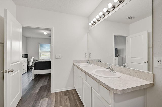 bathroom with hardwood / wood-style floors, a textured ceiling, and vanity