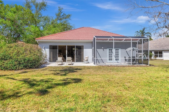 back of property featuring glass enclosure, a patio, a yard, and stucco siding