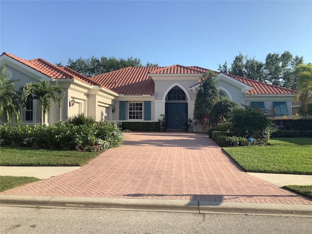 mediterranean / spanish house featuring a front yard