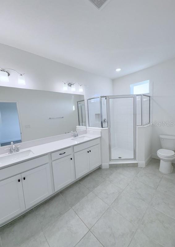 full bathroom featuring toilet, double vanity, a sink, and a shower stall