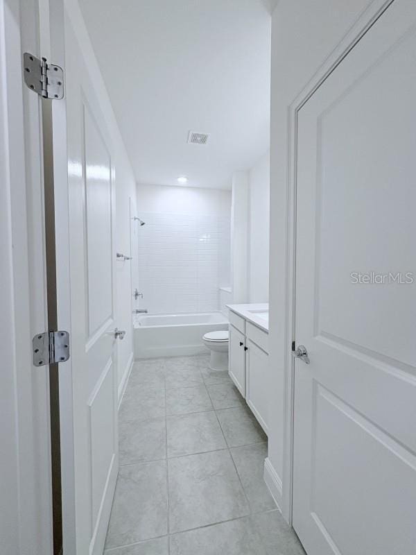 bathroom with visible vents, washtub / shower combination, toilet, vanity, and tile patterned floors