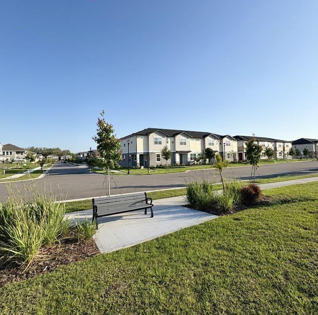 view of property's community with a residential view and a lawn