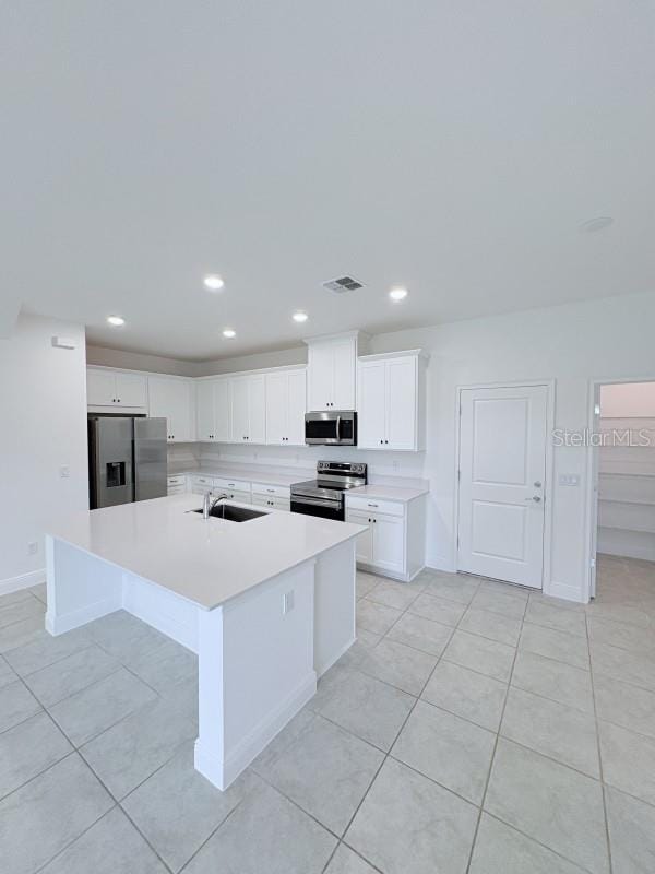 kitchen with light tile patterned floors, light countertops, white cabinetry, visible vents, and appliances with stainless steel finishes