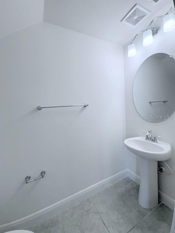 bathroom with tile patterned flooring, visible vents, and baseboards