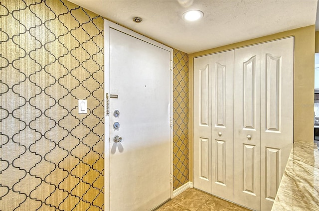 doorway to outside featuring a textured ceiling