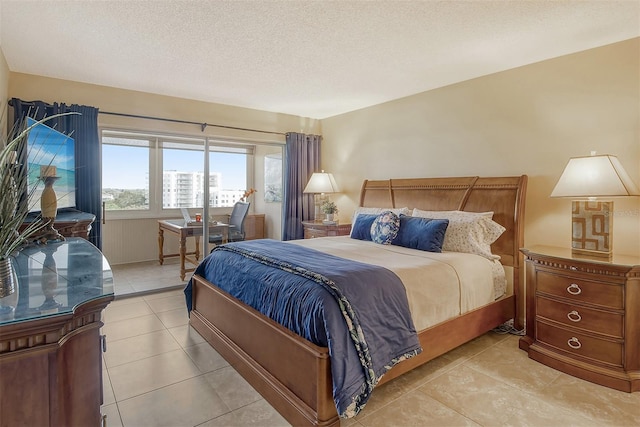 tiled bedroom featuring access to outside and a textured ceiling