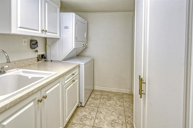 washroom featuring cabinets, stacked washer and clothes dryer, sink, and light tile patterned floors