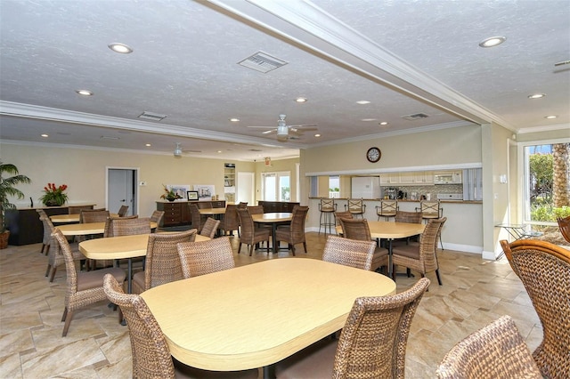 dining space with crown molding, ceiling fan, and a textured ceiling