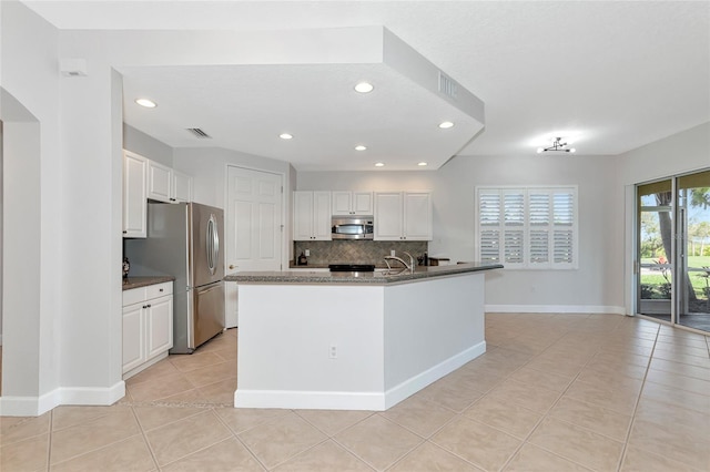 kitchen with white cabinetry, appliances with stainless steel finishes, and a center island with sink