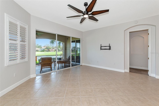 tiled empty room featuring ceiling fan