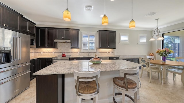 kitchen featuring pendant lighting, stainless steel appliances, and a kitchen island