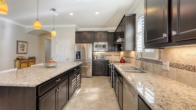 kitchen featuring appliances with stainless steel finishes, hanging light fixtures, light stone countertops, ornamental molding, and sink